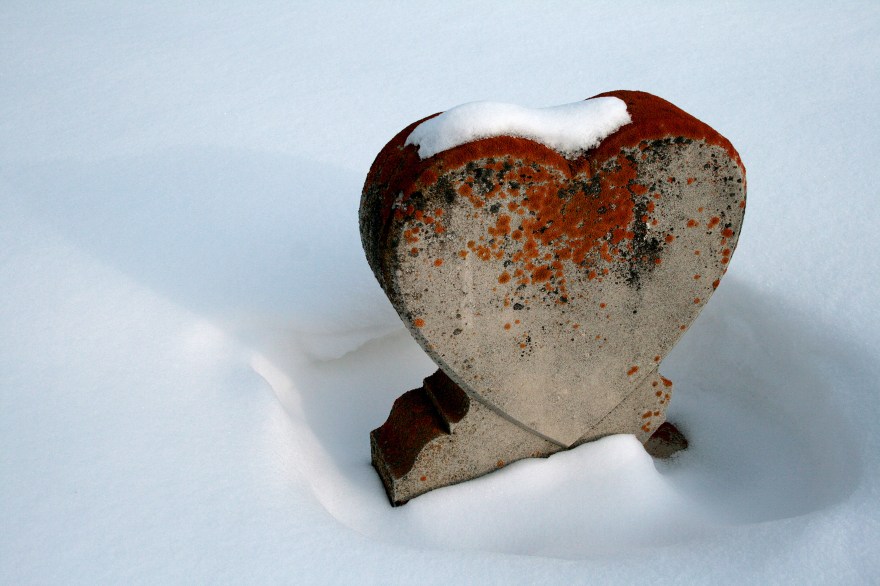 A heart shaped gravestone in the snow