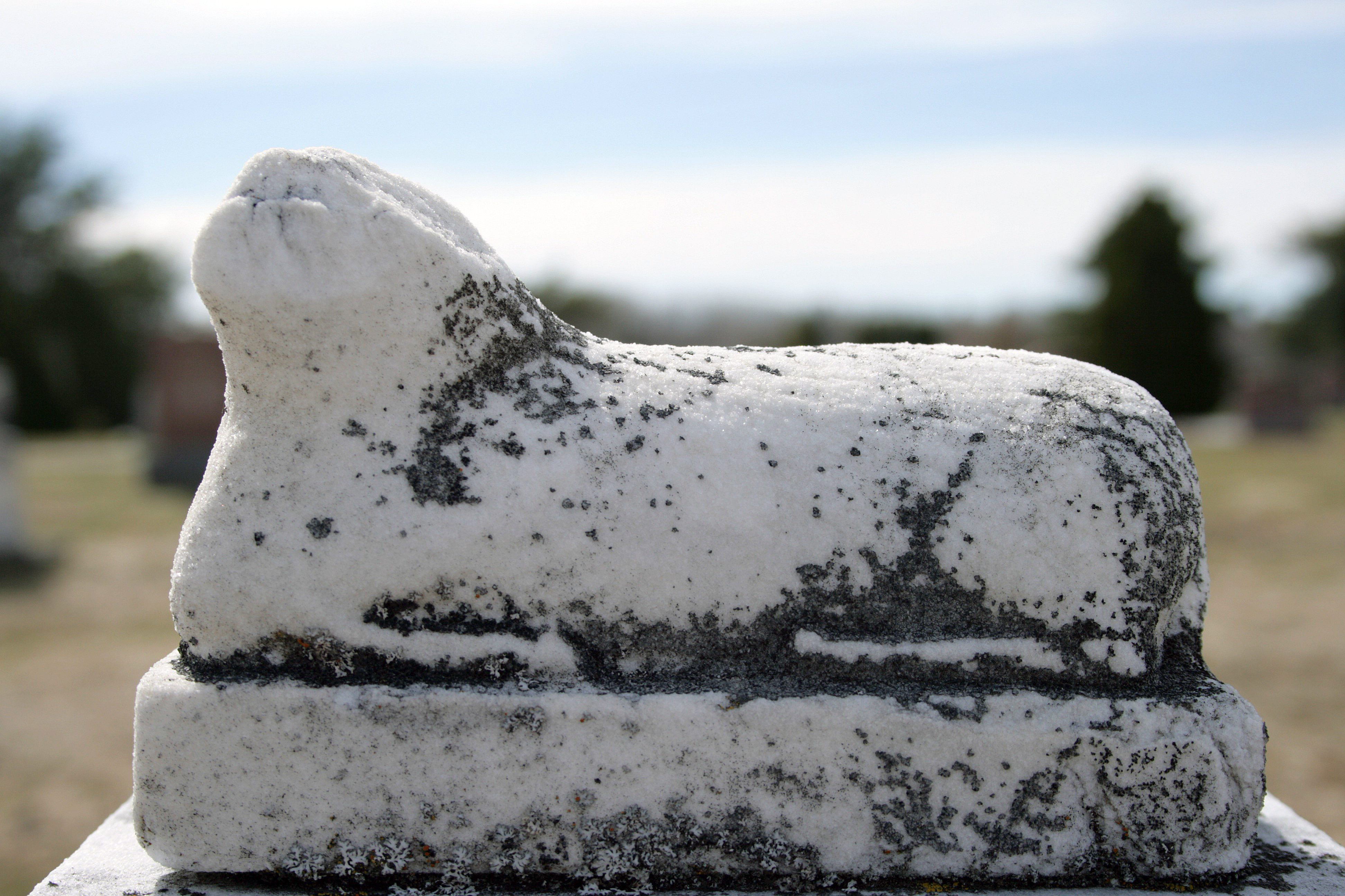 statue of a lamb that is broken and worn