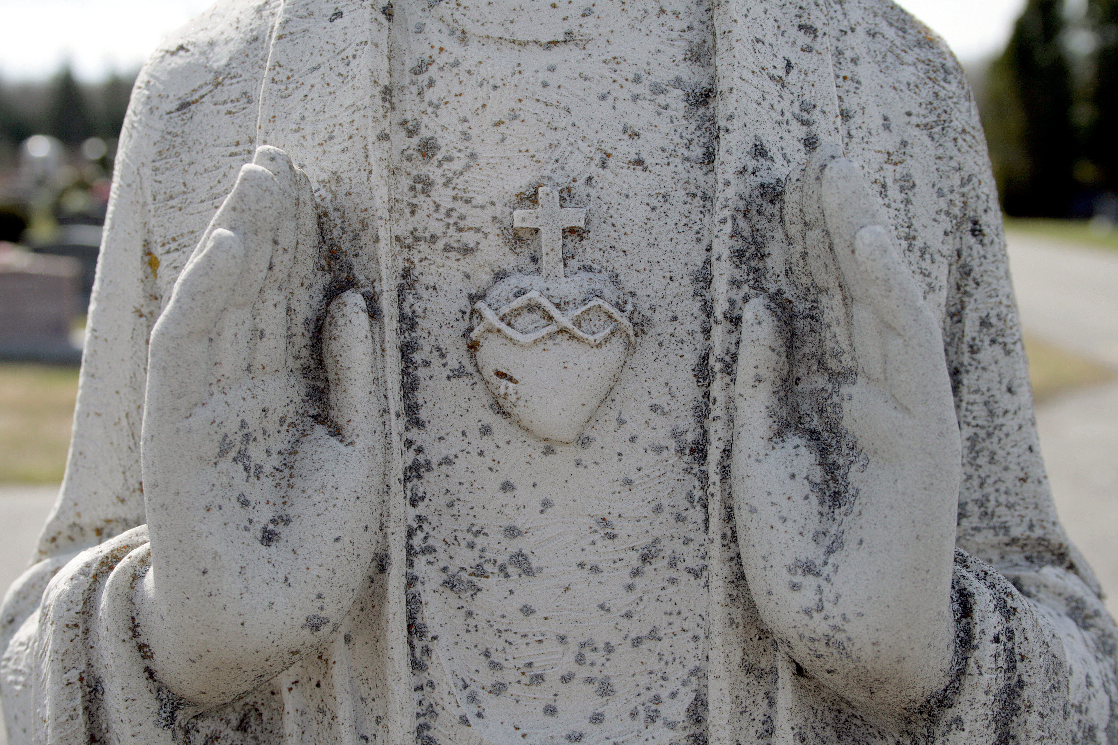 dirty white statue showing a heart with a cross