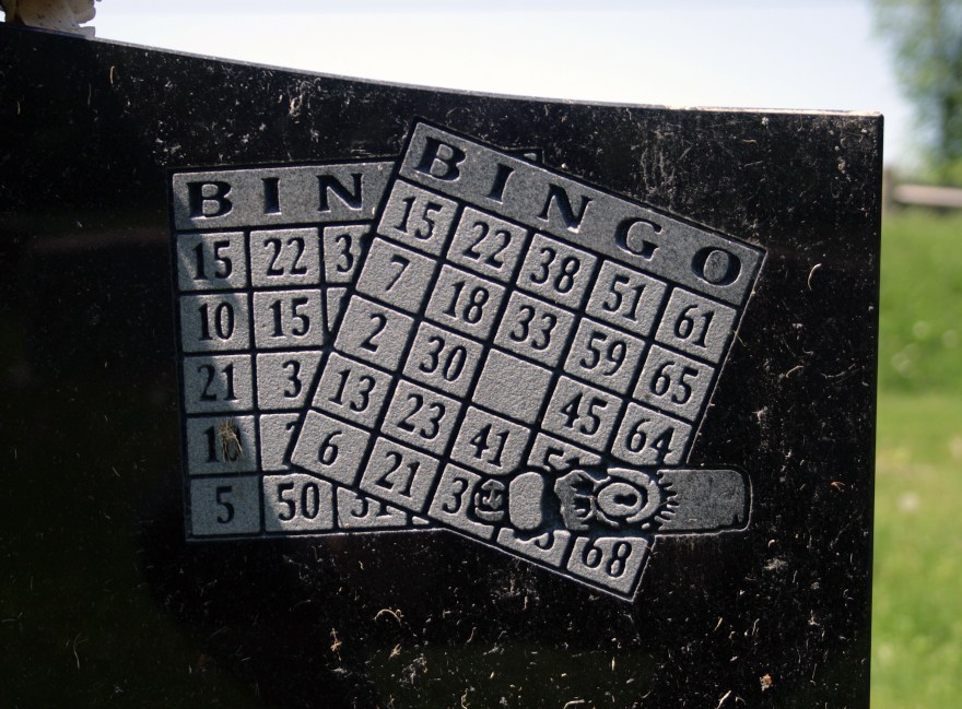 Two Bingo Cards and a bingo dabber, engraved on a headstone